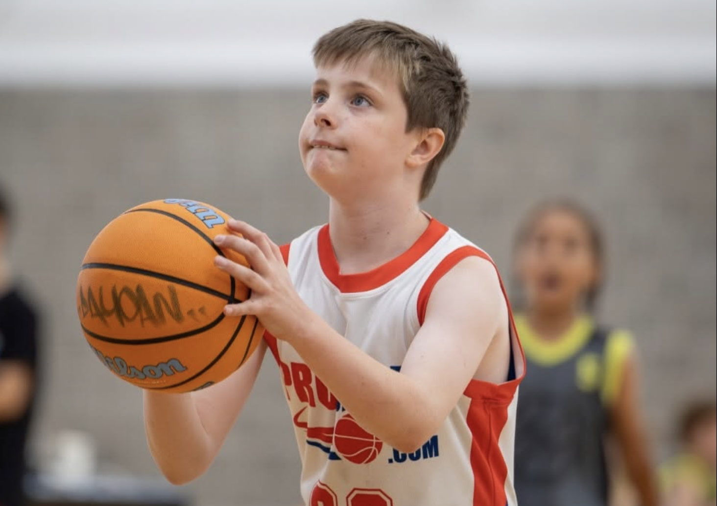 Young ProBall athlete holding a basketball during a game, representing the importance of recovery habits in youth basketball development.